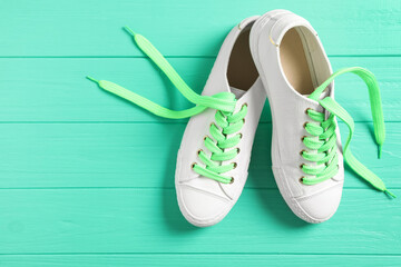 Pair of stylish shoes with laces on turquoise wooden background, flat lay. Space for text