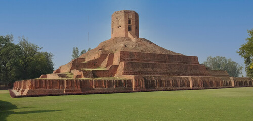 This is photo Chaukhandi Stupa with blue sky and grass in Sarnath Varanasi