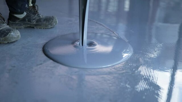 Pouring Self-Leveling Floors. Self-Leveling Floors On A Large Area, A Worker