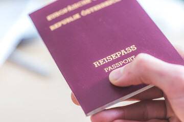 Passport vacation concept: Close up of fingers holding a passport, arrival or departure, “Reisepass Passport”