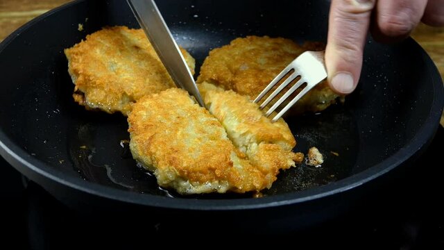 Toasted crispy crust golden potato pancakes or deruny fried in boiling oil in frying pan. Tasty draniki. Traditional european food. Domestic kitchen. Close-up.