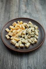 brown earthenware plate with two types of cheese, diced