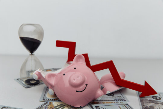 Broken piggy bank with hourglass and red arrow. Investment and bankruptcy concept