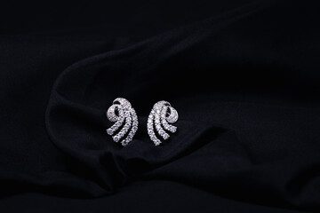 white gold diamond earrings isolated on black background