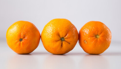 appetizing tangerines laid out in a row on white background