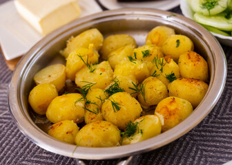 toasted young potatoes with dill in metal skillet