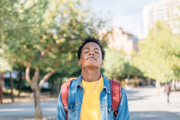 Relaxed boy breathes fresh air in a park