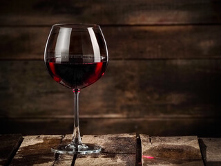 Red wine glass on rustic wooden background