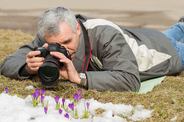 man photographing flowers
