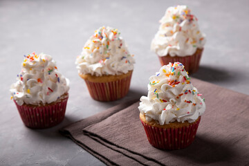 Tasty party cupcakes on the table. Cupcakes with whipped cream.