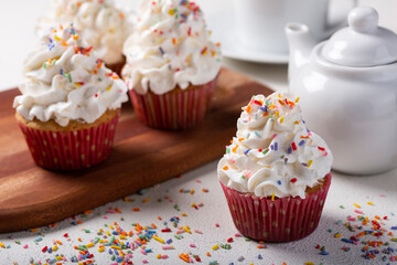 Tasty party cupcakes on the table. Cupcakes with whipped cream.