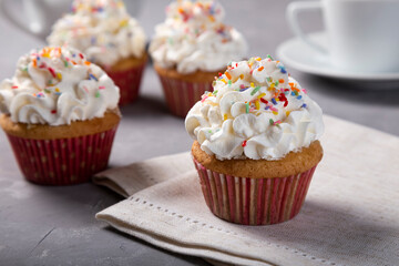 Tasty party cupcakes on the table. Cupcakes with whipped cream.