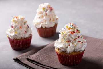 Tasty party cupcakes on the table. Cupcakes with whipped cream.