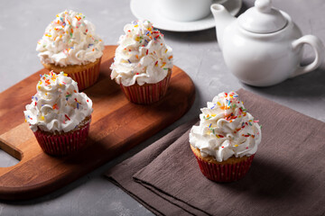 Tasty party cupcakes on the table. Cupcakes with whipped cream.