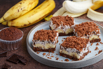 Delicious homemade chocolate dessert with banana, ricotta (cremcheese, mascarpone) and brownie. Mole cake. Portions of pie in a gray plate. Selective Focus
