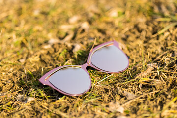 Fototapeta na wymiar Pink Sunglasses model for women with a very special design shoot outside in nature in a summer day . Selective focus . High quality photo