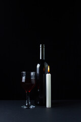 Wine and candle on a dark background. Creative photo of red wine on a black background. Wine and candle smoke