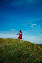 girl in a red skirt enjoys the summer in the field