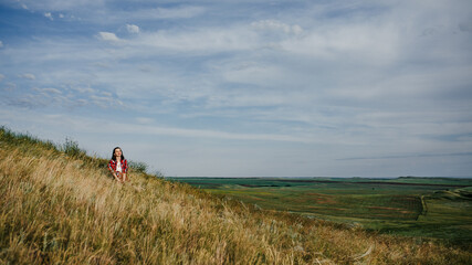 girl in a red skirt enjoys the summer in the field