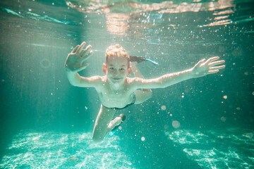 Cute little boy underwater in swimming pool 