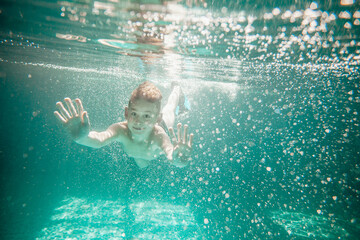 Cute little boy underwater in swimming pool 