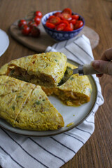 Spanish tortilla tapas dinner party. Homemade potato omelette for sharing with tomato salad. 