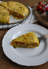 Tortilla pincho. Plated Spanish potato omelette pintxo on a set table. Serving slice of a tapa. 