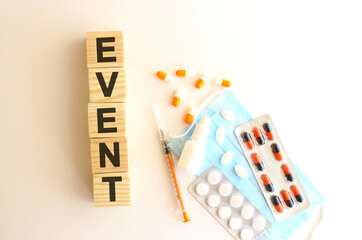 The word EVENT is made of wooden cubes on a white background. Medical concept.