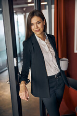 Stylish slim female employee daydreaming during the coffee break