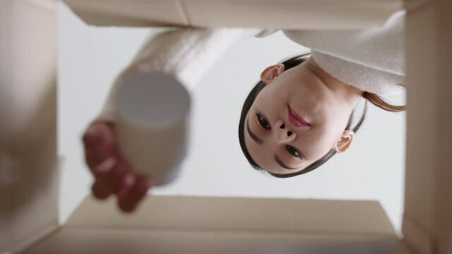 Bottom up inside box view asia woman open medicine carton receive postal parcel mail, look inside aid box at home. Girl unbox pharmacy package delivery service telehealth telemedicine online concept.