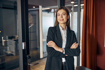 Pleased businesswoman in business attire looking ahead