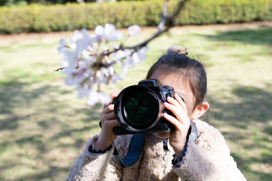 一眼レフカメラで写真を撮る少女