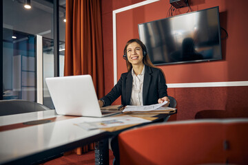 Pleased draftswoman with a technical drawing seated at the desk