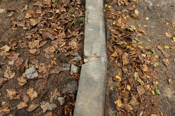 poorly executed road repairs. replacing the old curb stone with a new one