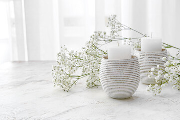 Composition with candles and flowers on table in room