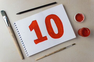 Red number ten drawing on a white album sheet. To indicate the place, price, etc.