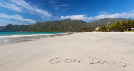 Calm Tropical Beach With Inscription Con Dao Written On A Sand
