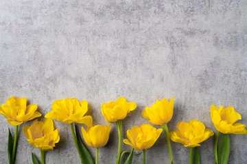 Konzept des Muttertagsgrußes mit gelbem Tulpenstrauß auf grauem Hintergrund © RomixImage