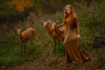 Redhead girl with deer in a long dress