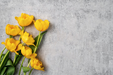 Concept of Mother's day holiday greeting with yellow tulip bouquet on gray background