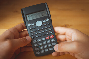 Calculator in hands with the calculation 1+1=2