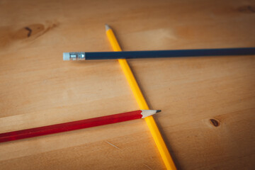 Pencils on table in the colours yellow, red and blue.
