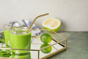 Tray with glasses of healthy green smoothie on table