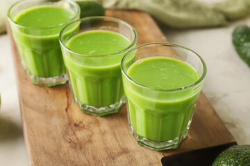 Glasses of healthy green smoothie on table, closeup