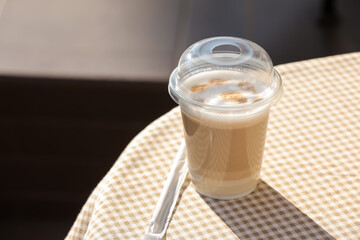 Takeaway cup of tasty latte on table in cafe, closeup