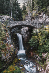 Fototapeta na wymiar Christine Falls, a waterfall on Van Trump Creek in Pierce County, Washington, best known for the beautifully detailed brick arch of Christine Falls Bridge, Mount Rainier National Park. 