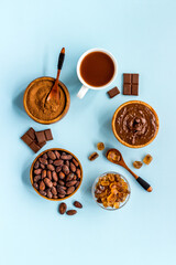 Cocoa beans and powder with hot chocolate in white cup. Top view, flat lay