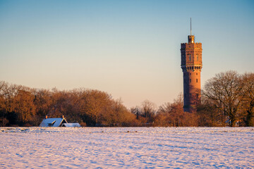 Dutch winter landscape with the water tower of Delden, in the eastern part of The Netherlands. Snow has fallen on a cold February day. The cities of Almelo and Hengelo and the German border are near.