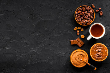 Cocoa beans and powder with hot chocolate in white cup. Top view, flat lay