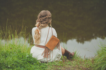 Meditative woman with blonde hair at the lake outdoors